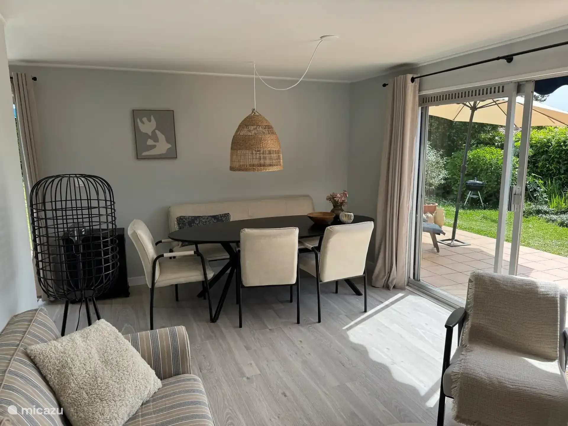 De woonkamer met eettafel en de schuifpui naar het terras